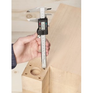 Suwmiarka cyfrowa LUX 150 mm Comfort podczas pomiaru kawałka drewna.