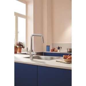 Zestaw baterii kuchennej Grohe Blue Pure Start z filtrem węglowym w kolorze srebrnym na tle kuchni.