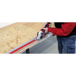 Mini pilarka tarczowa Einhell w użyciu z szyną prowadzącą na płycie drewnianej.