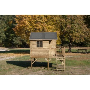 Drewniany domek do zabawy t.b.t. na palach z drabinką i małym balkonem na tle jesieni.