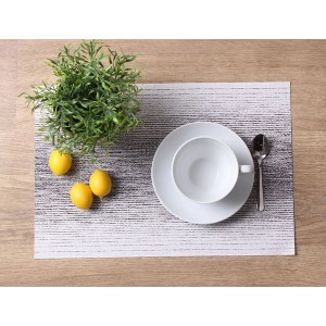 Podkładka ze wzorem, naczynia i dekoracja na drewnianym stole.