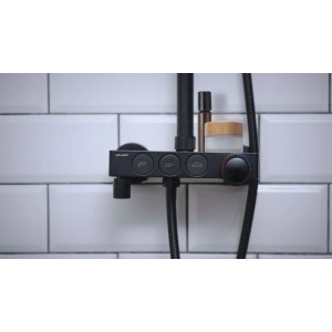 Czarna bateria prysznicowa z półką i elementami sterującymi na tle białych płytek.