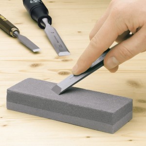 Kamień ostrzący LUX Classic z dłutem na drewnianym podłożu. Narzędzie do ostrzenia strugów i dłut.