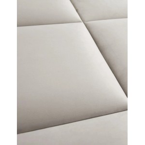 Zbliżenie jasnego, tapicerowanego panelu ściennego.