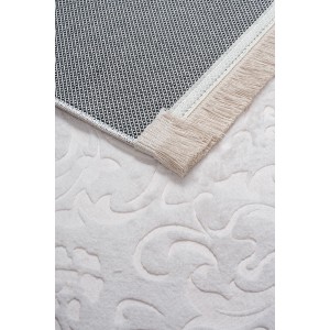 Zbliżenie białego dywanu z krótkim włosiem t.b.t. z frędzlami i wzorem.