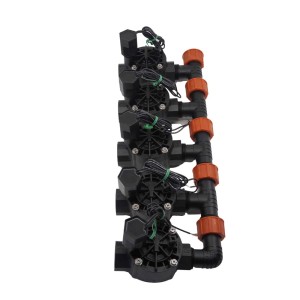 Wiele czarnych zaworów t.b.t. do nawadniania podziemnego z pomarańczowymi złączkami.