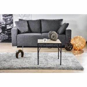 Dekoracyjny salon z szarą sofą, dywanem i stolikiem bocznym.