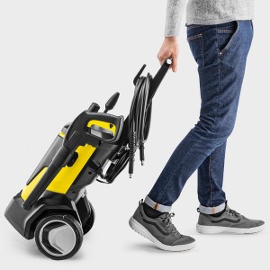 Żółto-czarna myjka ciśnieniowa z teleskopowym uchwytem w użyciu.