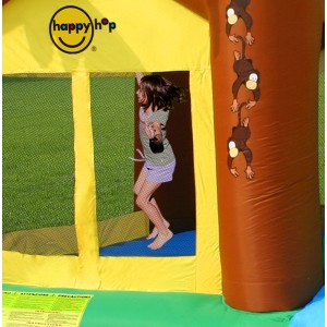 Dziecko skacze w żółto-brązowym dmuchanym zamku z motywem małp. Kategoria: Place zabaw.