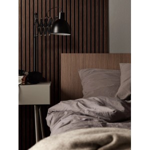 Sypialnia z panelami ściennymi t.b.t. o wyglądzie drewna za łóżkiem i szafką nocną.