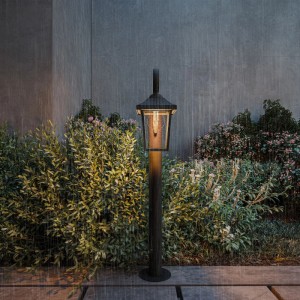 Czarna lampa ogrodowa Philips Buzzard (75 cm) w ogrodzie podczas deszczu. Odporna na warunki atmosferyczne.