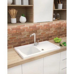 Biały ceramiczny zlew t.b.t. z ociekaczem i baterią na blacie kuchennym.