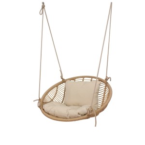 Rattanowy fotel wiszący z beżowymi poduszkami, idealny do relaksu w ogrodzie lub na tarasie.