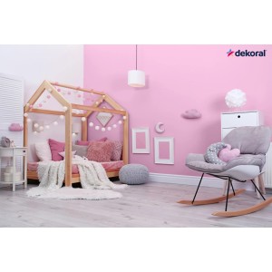 Różowy pokój dziecięcy z łóżkiem w kształcie domku, fotelem bujanym i farbą do ścian. t.b.t.