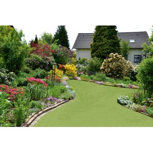 Zielona sztuczna trawa w ogrodzie z kwiatami i drzewami. Sztuczna trawa t.b.t.