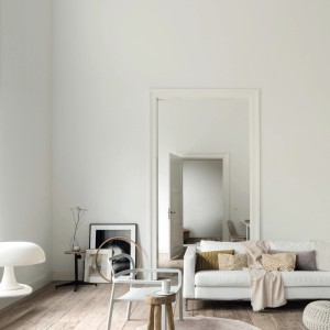 Pokój dzienny z farbą do ścian t.b.t. w kolorze białym, sofa, krzesło i dekoracje.