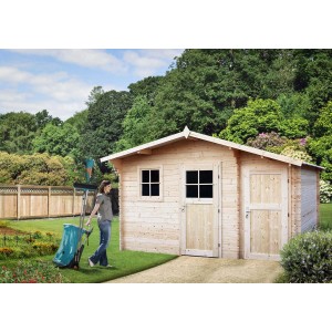 Drewniany domek ogrodowy t.b.t. z oknem i drzwiami w ogrodzie. Kobieta ciągnie zbieracz liści.