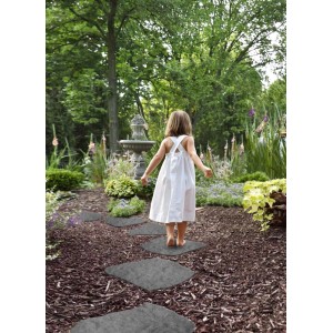 Dziewczynka na ścieżce z szarych płyt tarasowych t.b.t. w ogrodzie.