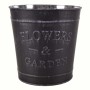 Dekoracyjna, ciemna metalowa osłonka z napisem "Flowers & Garden" na kwiaty i rośliny.