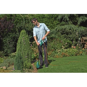 Mężczyzna używa elektrycznej podkaszarki t.b.t. w ogrodzie.