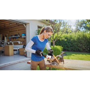 Kobieta szlifuje metalową rurę akumulatorową szlifierką kątową Bosch PWS 18V-70. Lecą iskry.