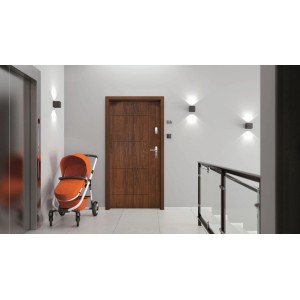 Brązowe drzwi zewnętrzne t.b.t. w nowoczesnym korytarzu z wózkiem i windą.