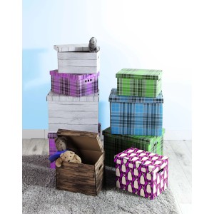 Różne dekoracyjne pudełka kartonowe ułożone na dywanie.