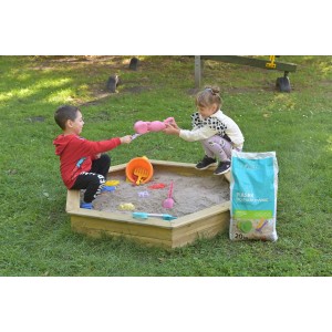 Sześciokątna drewniana piaskownica z bawiącymi się dziećmi i workiem piasku w ogrodzie.