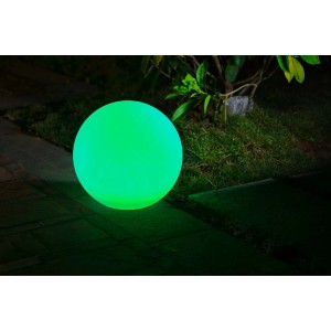 Świecąca zielona kula jako solarna lampa ścieżkowa w ogrodzie.