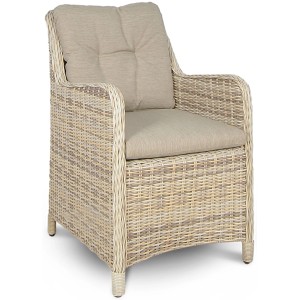 Rattanowy fotel z beżowymi poduszkami, część zestawu mebli ogrodowych.