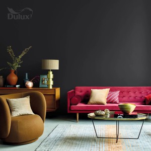 Pokój dzienny z farbą do ścian t.b.t. firmy Dulux w kolorze ciemnoszarym, w połączeniu z meblami w ciepłych kolorach.