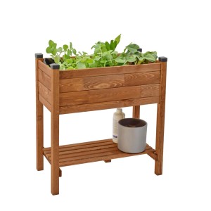 Drewniana podwyższona grządka z roślinami i półką na narzędzia ogrodnicze.