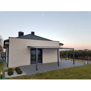 Nowoczesna wiata garażowa t.b.t. z szarą ramą przy domu.