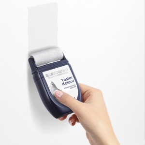 Dłoń trzyma wałek do malowania ścian. Widoczna aplikacja farby.