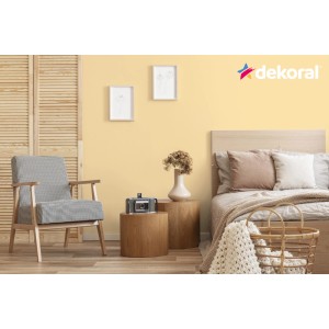 Pokój dzienny z żółtą ścianą pomalowaną farbą do ścian t.b.t. firmy Dekoral.