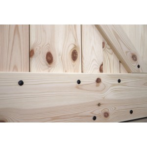 Zbliżenie drewnianych drzwi (t.b.t.) z deskami i czarnymi okuciami.