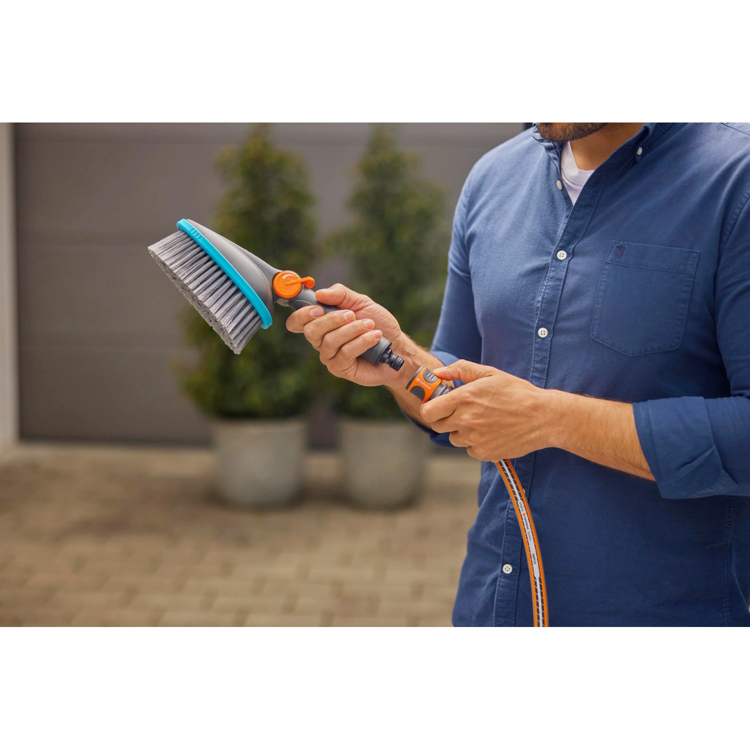Szczotka ręczna Gardena Cleansystem Soft M z przyłączem węża w akcji.