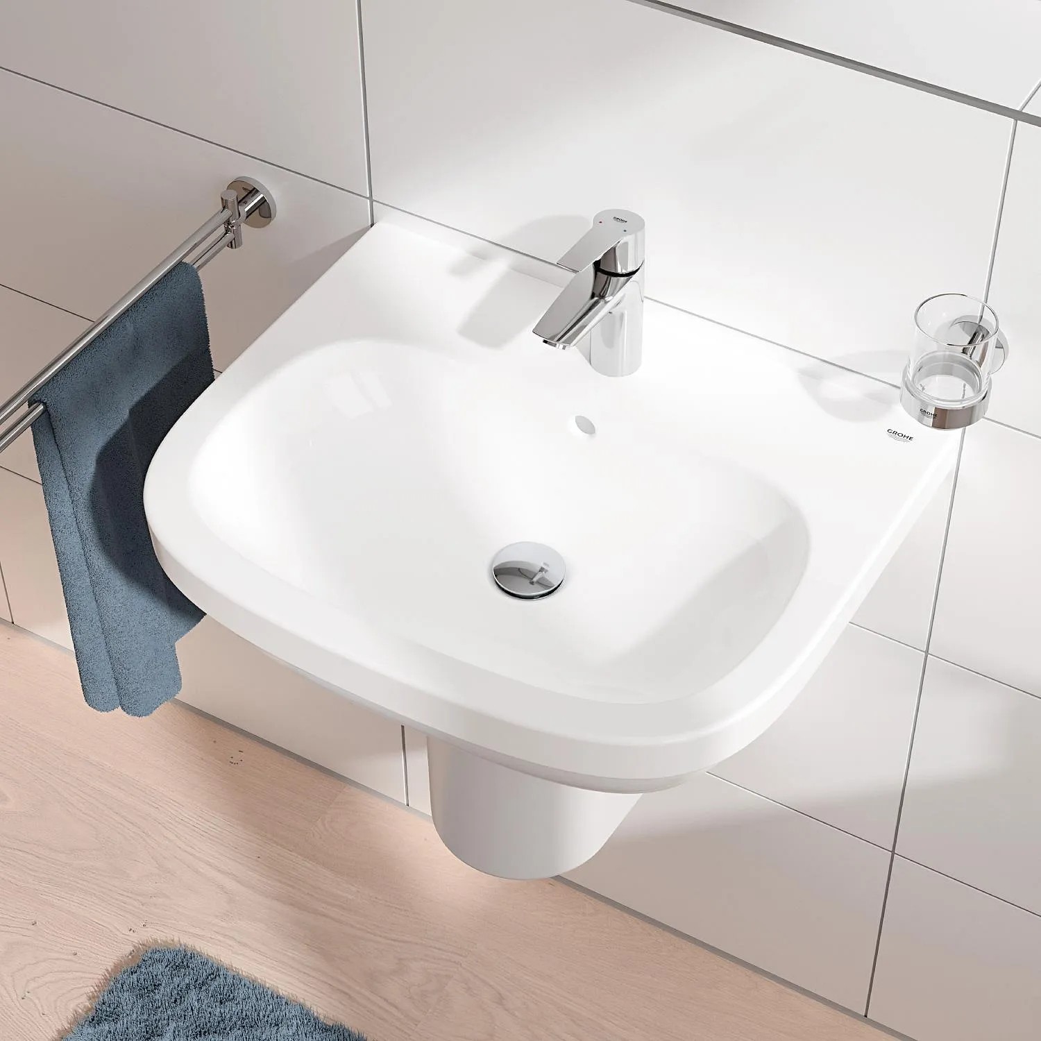 Bateria umywalkowa Grohe QuickFix Start S-Size z zestawem odpływowym Push-open na białej umywalce.