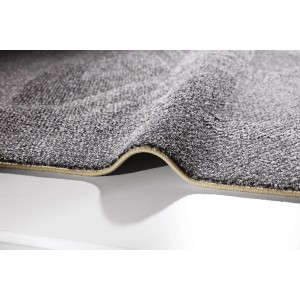 Zbliżenie szarego dywanu z długim włosiem t.b.t. z beżową krawędzią.