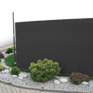 Czarna mata osłonowa t.b.t. jako ogrodzenie z roślinami w ogrodzie.