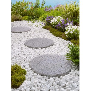 Ścieżka ogrodowa z okrągłymi płytami tarasowymi t.b.t. i białymi kamykami ozdobnymi.