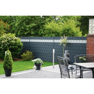 Szara mata ogrodzeniowa t.b.t. w ogrodzie z roślinami i meblami ogrodowymi.