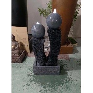 Dekoracyjna fontanna ogrodowa z dwiema szarymi kulami na kolumnach.