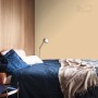 Aranżacja ściany z farbą do ścian t.b.t. w sypialni z niebieskim łóżkiem.