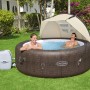 Bestway LAY-Z-SPA z zadaszeniem przeciwsłonecznym w ogrodzie, dwie osoby relaksują się w jacuzzi.
