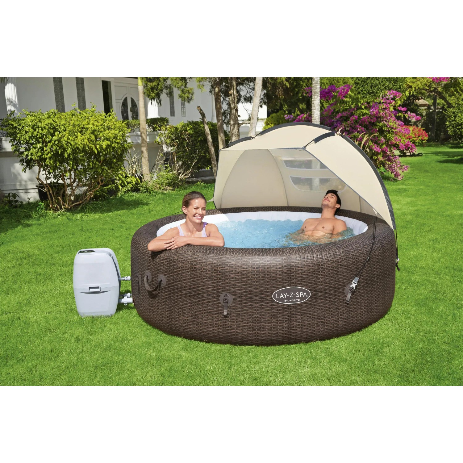Bestway LAY-Z-SPA z zadaszeniem przeciwsłonecznym w ogrodzie, dwie osoby relaksują się w jacuzzi.