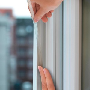 Nakładanie przezroczystej uszczelki okiennej Tesamoll na ramę okienną.