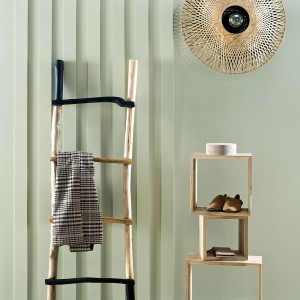 Dekoracyjna drewniana drabina z tekstyliami i półkami na tle zielonej ściany. Kolorowe farby do ścian.