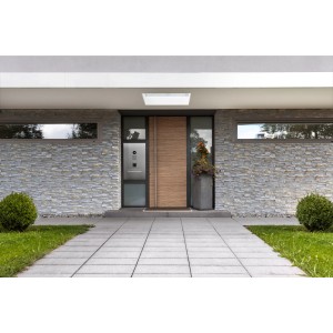 Fasada domu z szarym t.b.t. i nowoczesnymi drzwiami wejściowymi.