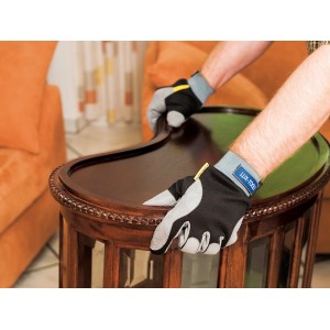 Czarne rękawice robocze LUX Soft Protect rozmiar 10 podczas polerowania mebli.